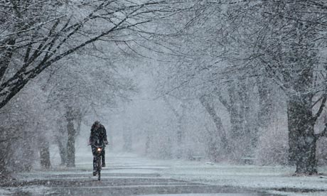 Bike blog : A young woman rides a bicycle under heavy snowfall